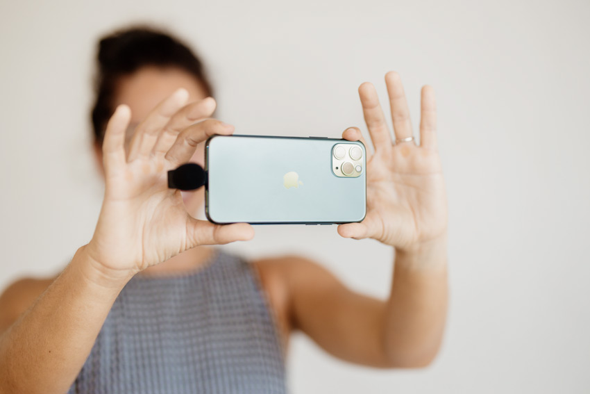 women holding a smartphone while live streaming
